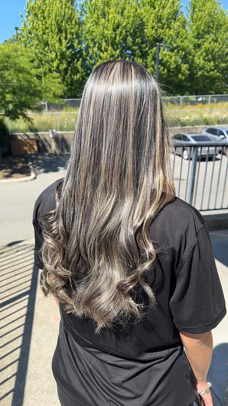 Long ash-blonde hair with darker roots and loose waves outdoors