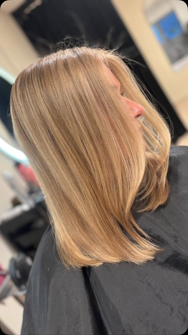 Shoulder-length ash bronde hair with blended brown-blonde tones in a salon