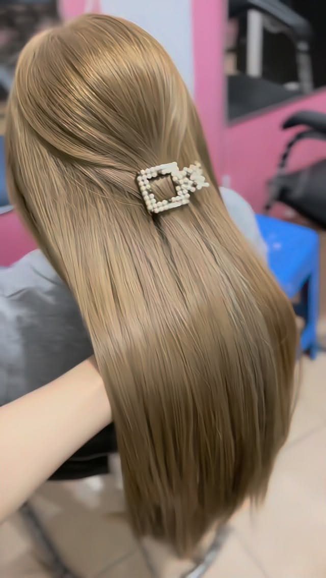Long cool blonde hair secured with a rectangular pearl-beaded clip