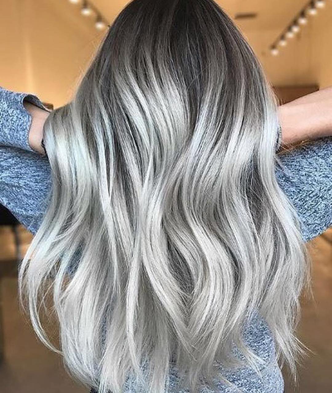 Long wavy silver ash blonde hair with dark roots and smoky lowlights