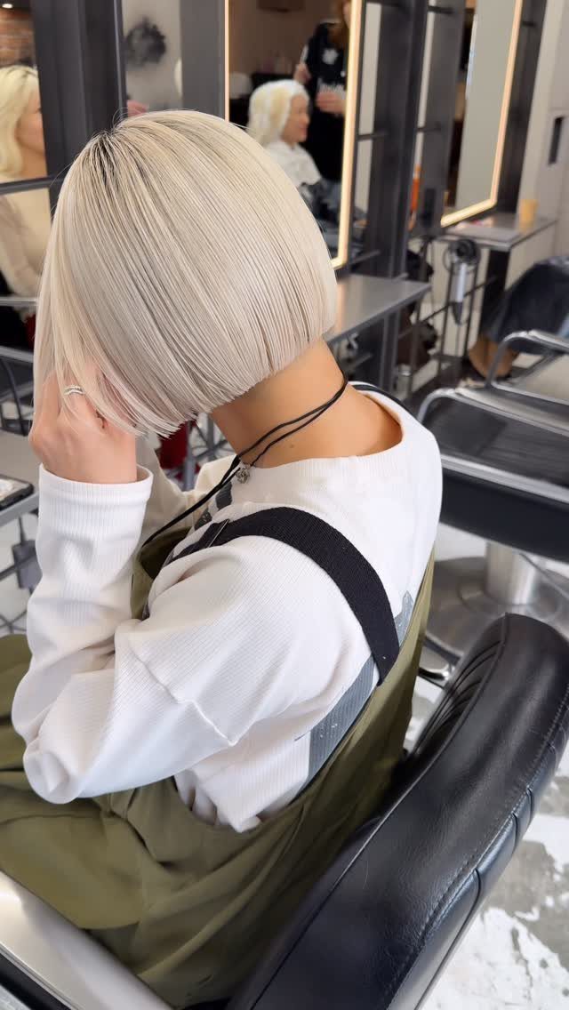 White ash blonde bob with a sleek side-swept fringe in a salon chair