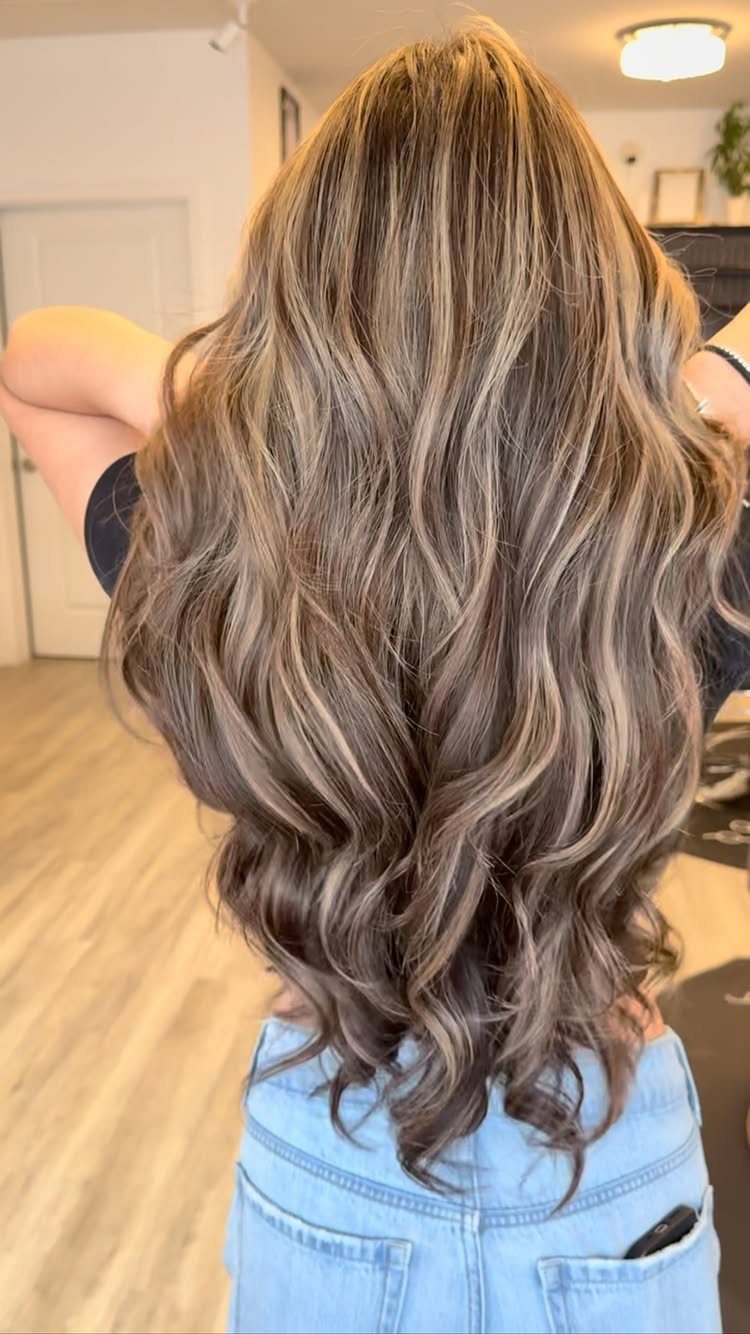 Long wavy ash-blonde hair blends cool beige and warm caramel highlights