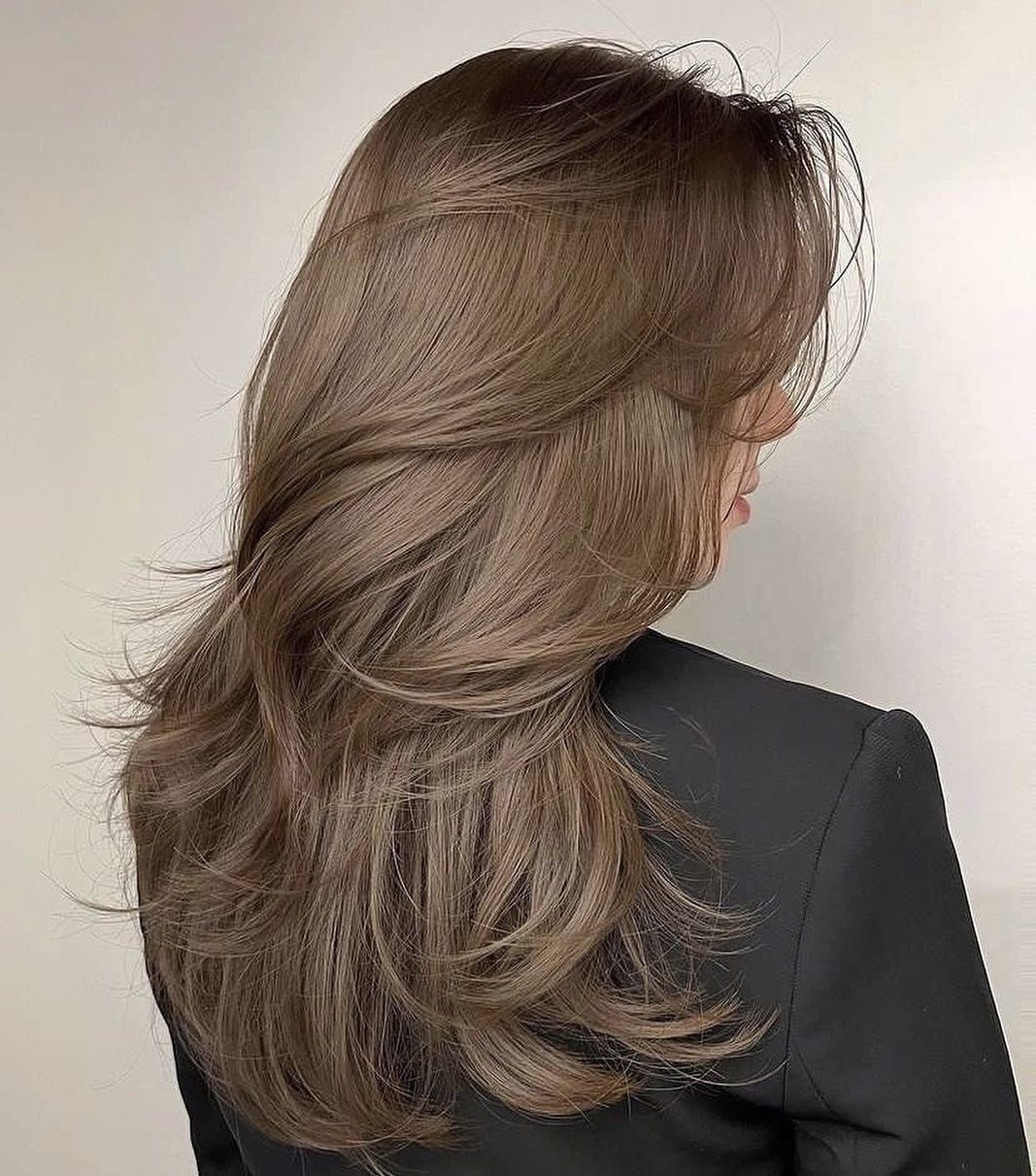 Long layered dark ash blonde hair with muted silvery brown tones