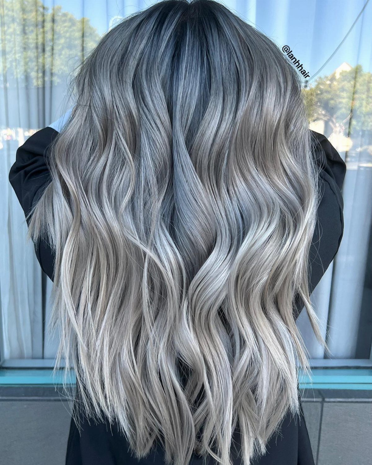 Long wavy pearl ash-blonde hair with dark roots and luminous silver tones