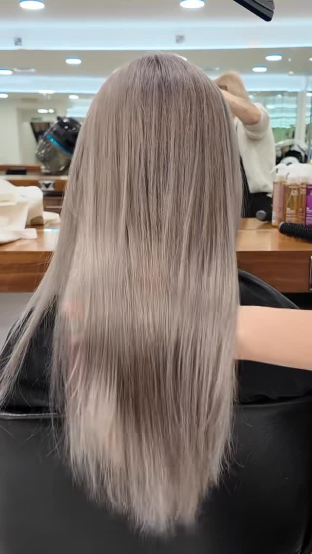 Long, straight ash beige blonde hair shown from behind in a salon