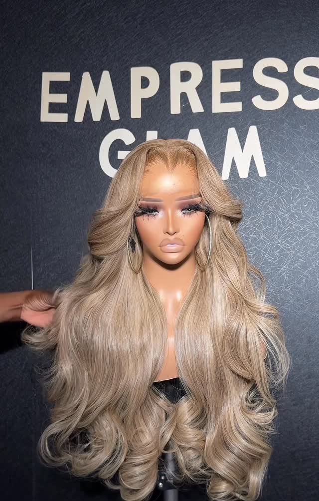 Woman with long beige blonde hair in voluminous curls and face-framing layers