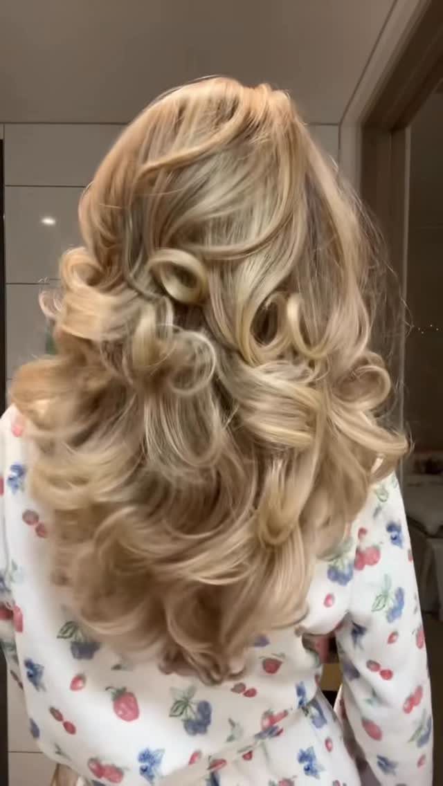 Long beige blonde layers styled in a voluminous curled blowout
