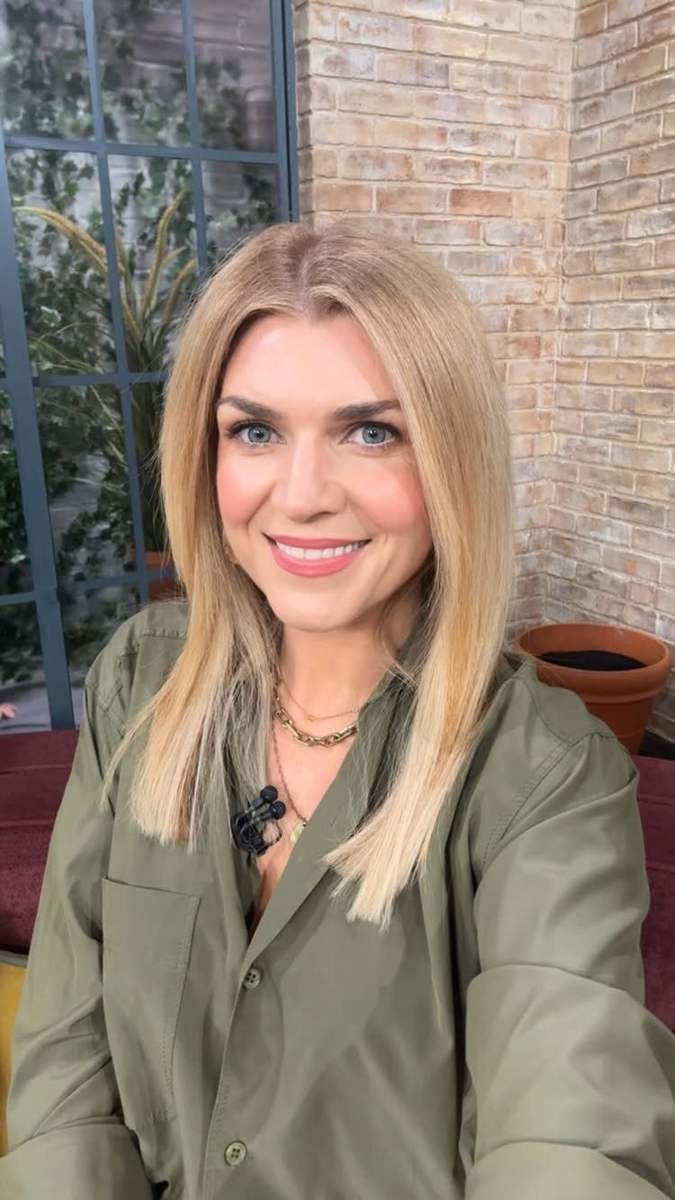 Woman showing long lived-in beige blonde hair with darker roots and soft dimensional color