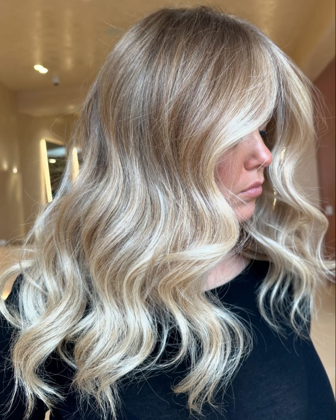 Woman with beige blonde waves and light face-framing layers