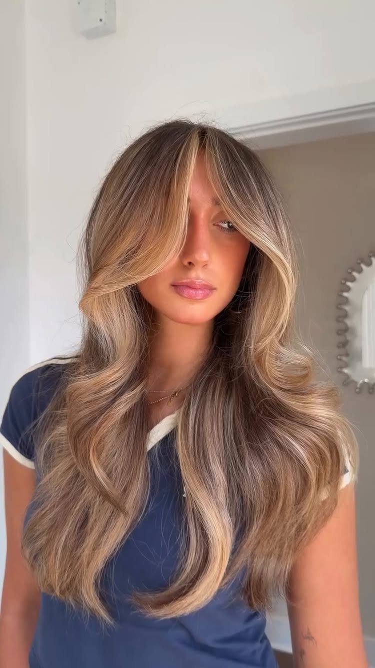 Woman with long sun-kissed beige blonde hair styled in soft waves