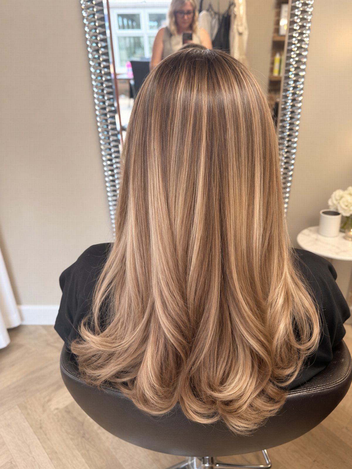 Long beige-blonde hair with blended shades and softly curled ends