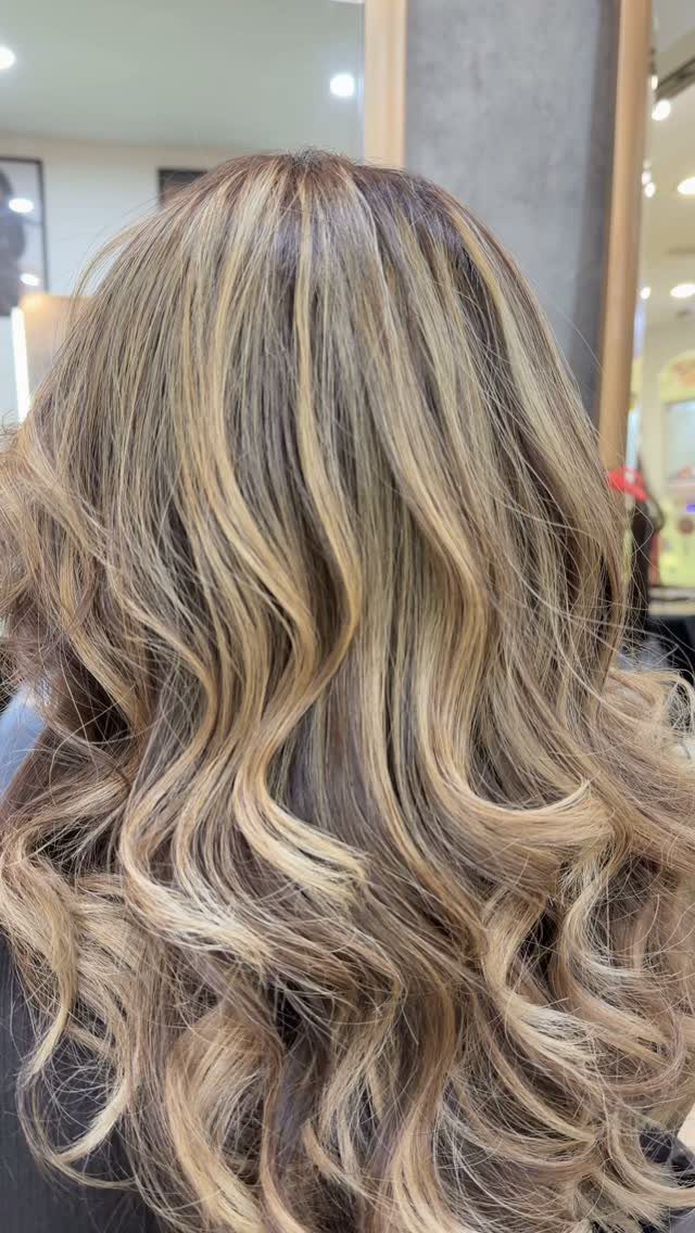 Long curled dark hair with thick blonde ribbons and contrasting highlights