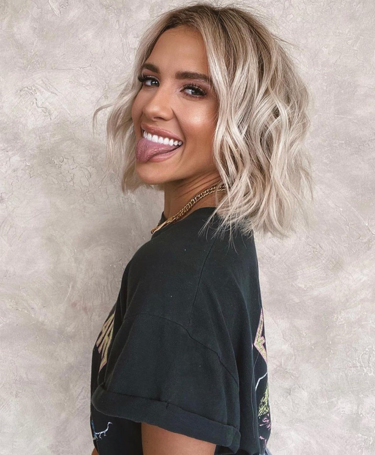 Smiling woman with a tousled blonde bob and loose beachy waves