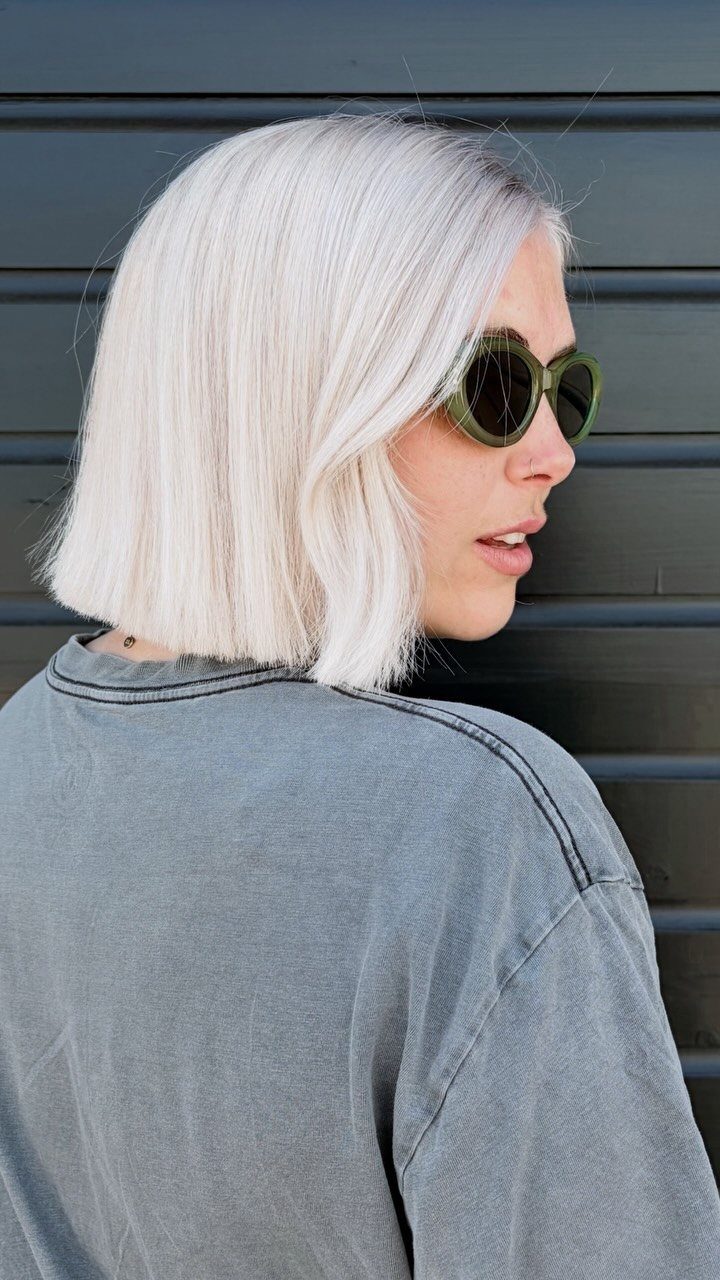 Woman showing a blunt platinum blonde bob with straight, chin-length ends
