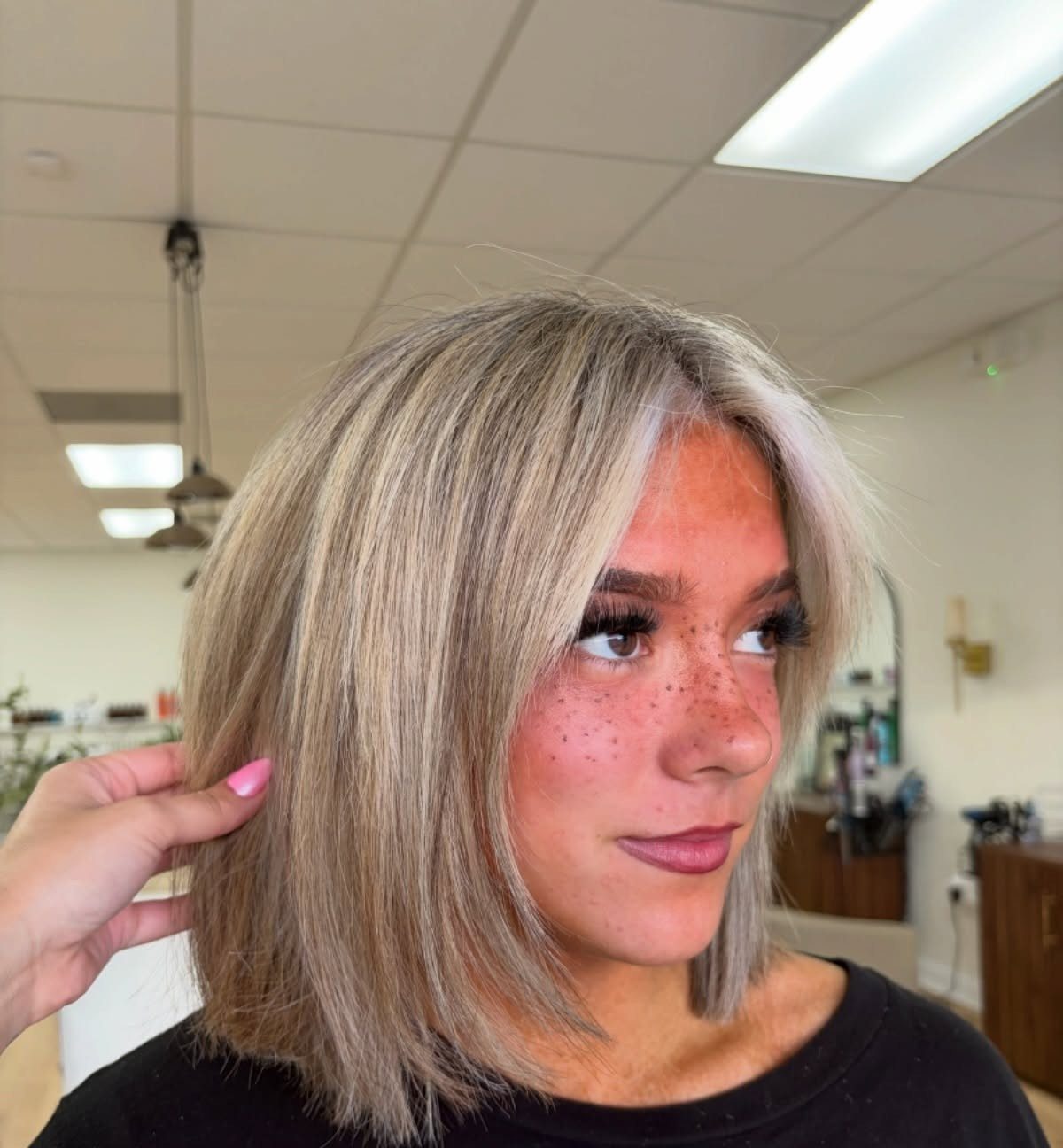 Blonde woman with a chin-length bob and center-parted fringe in a salon