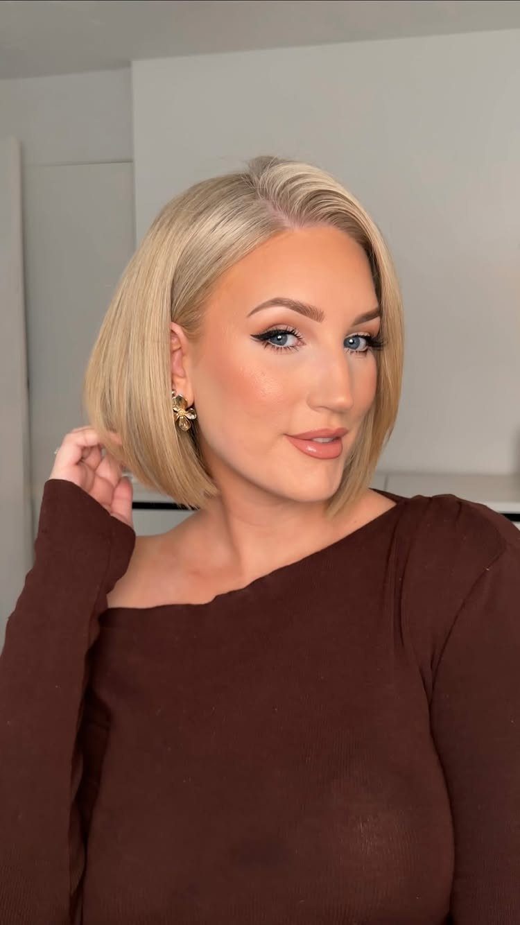 Blonde woman showing a sleek chin-length bob with a deep side part