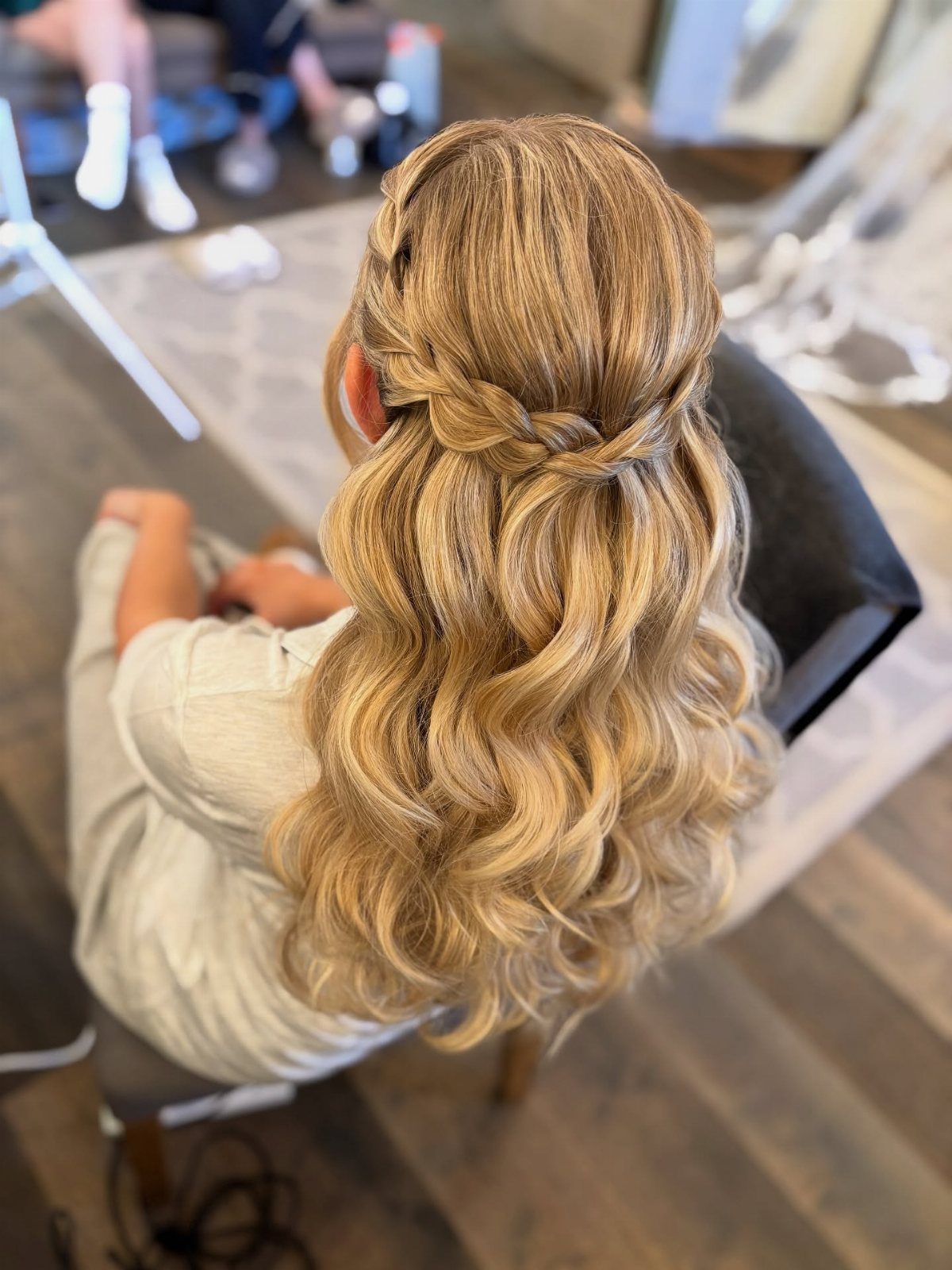 Braided half-back holds long golden-blonde curls away from the face
