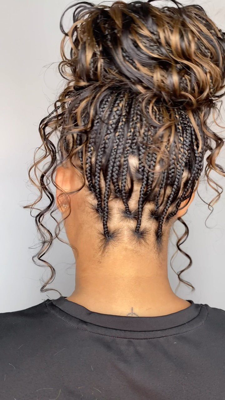 Blonde and dark curly hair gathered in a braided high bun