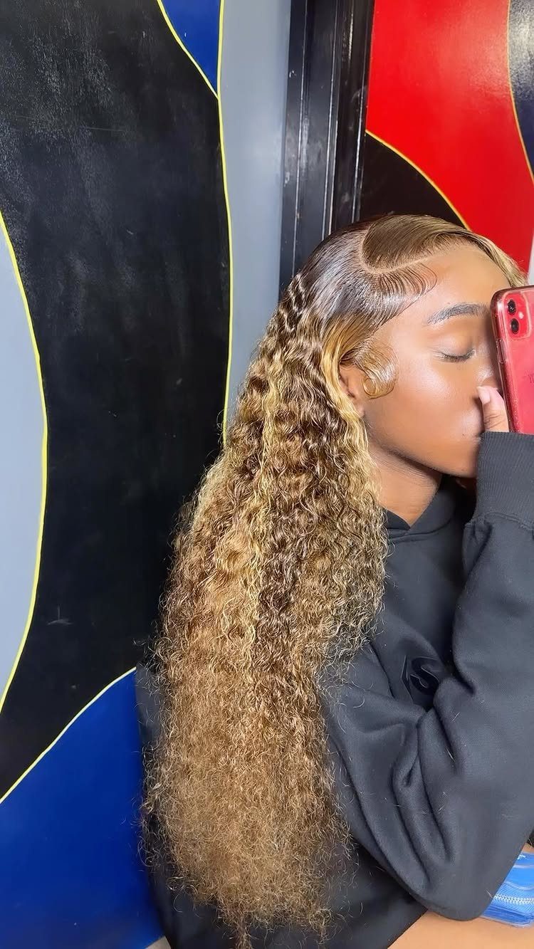 Woman with long golden blonde curls wears a deep side part