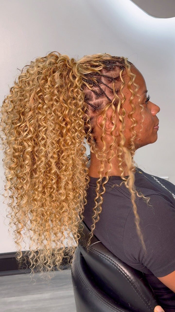 Blonde curly ponytail with small side twists shown in a salon chair