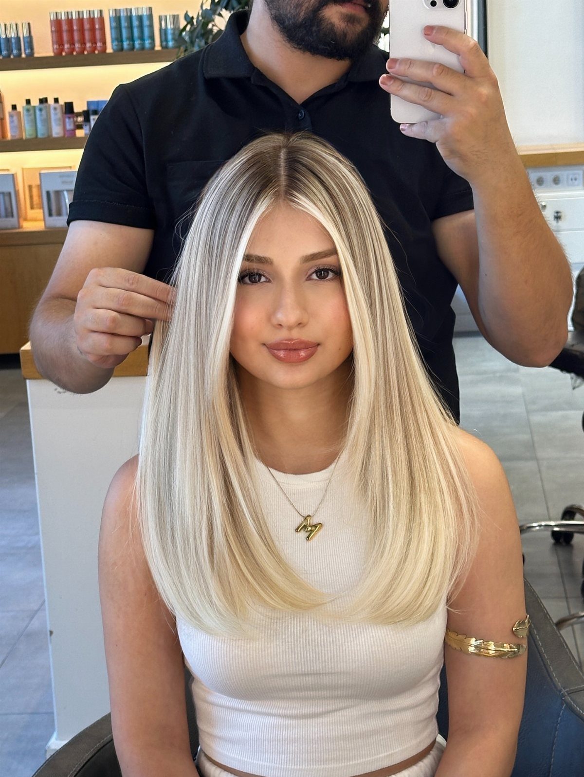 Long blonde hair with bright face-framing highlights in a salon