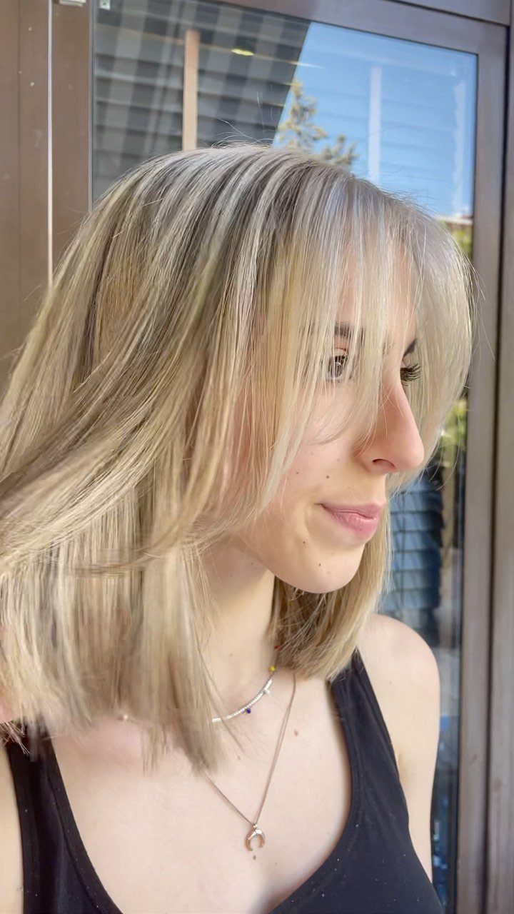 Woman with finely highlighted golden blonde hair in soft layered lengths