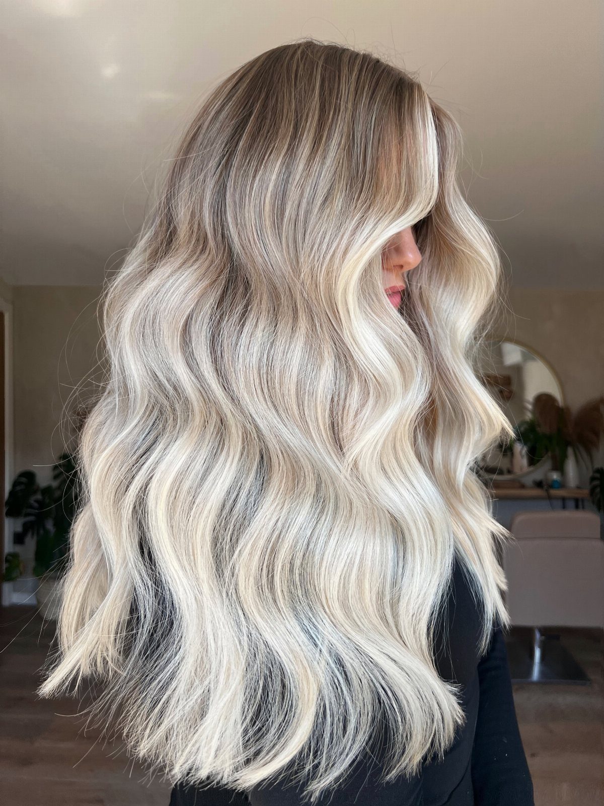 Long wavy blonde balayage with contrasting pale and beige shades and dark roots