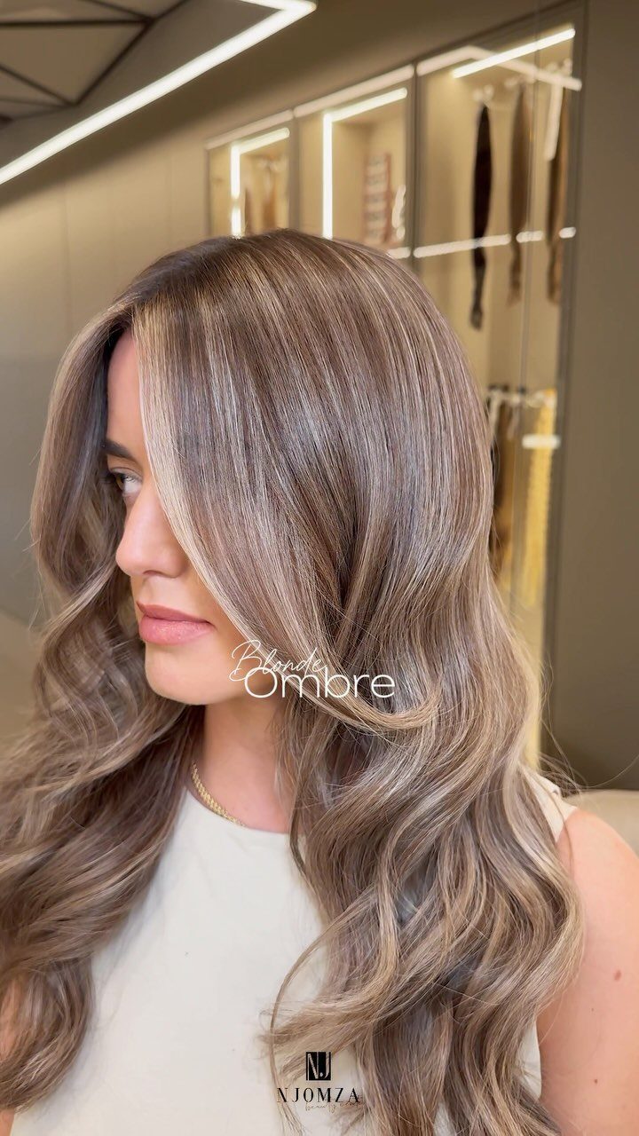 Woman with long ash-brown hair gradually fading to lighter blonde ends