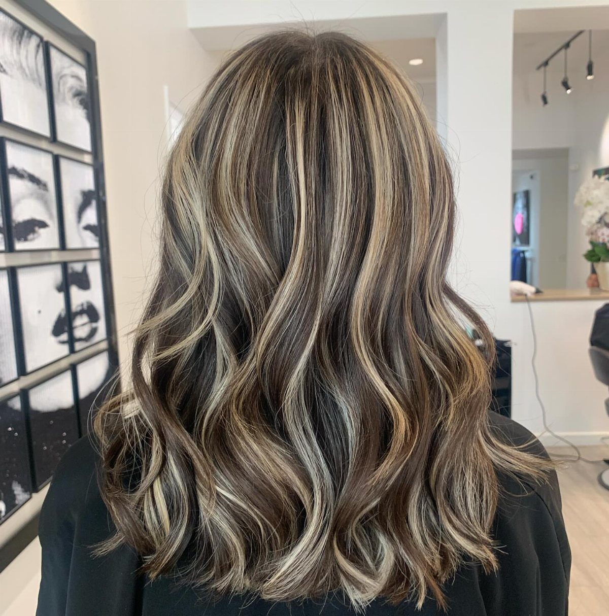 Wavy chocolate brown hair with blonde highlights and dimensional color