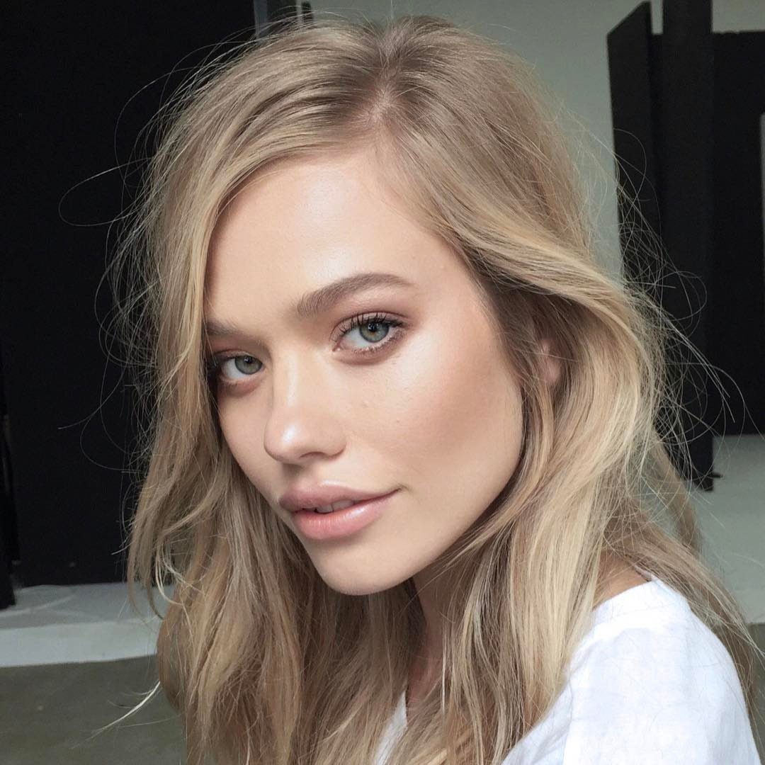 Woman with long pale ash blonde hair parted to the side