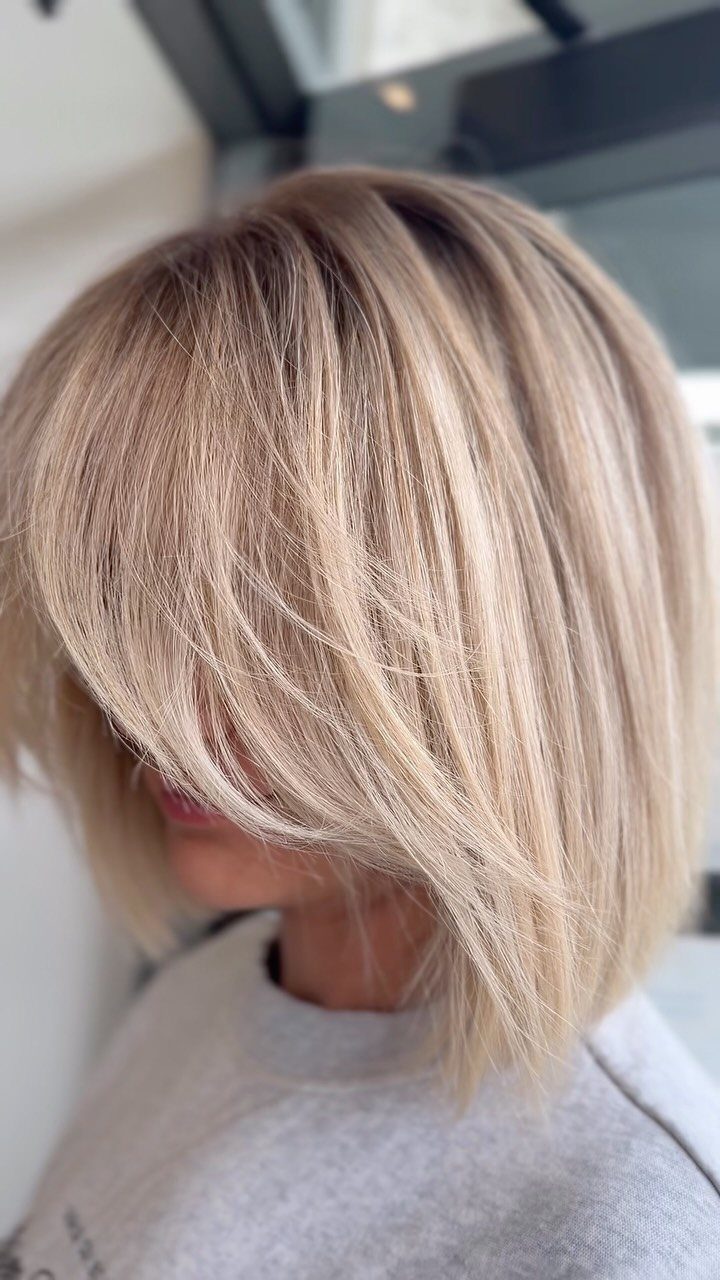 Light blonde bob with layered ends and a long side-swept fringe