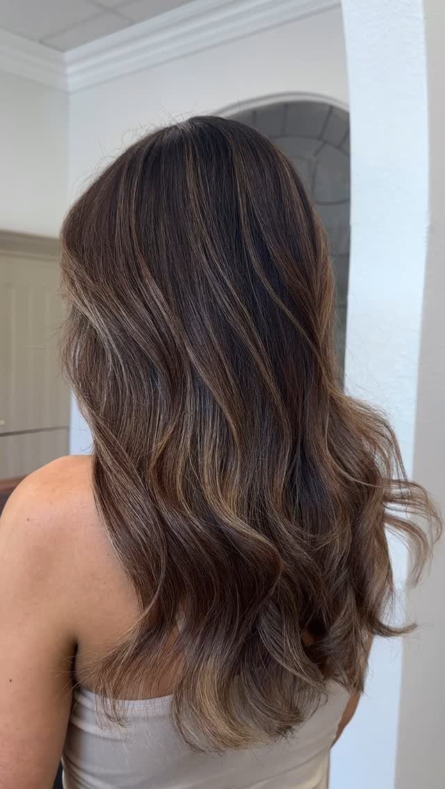 Long wavy brown hair with blended blonde balayage highlights