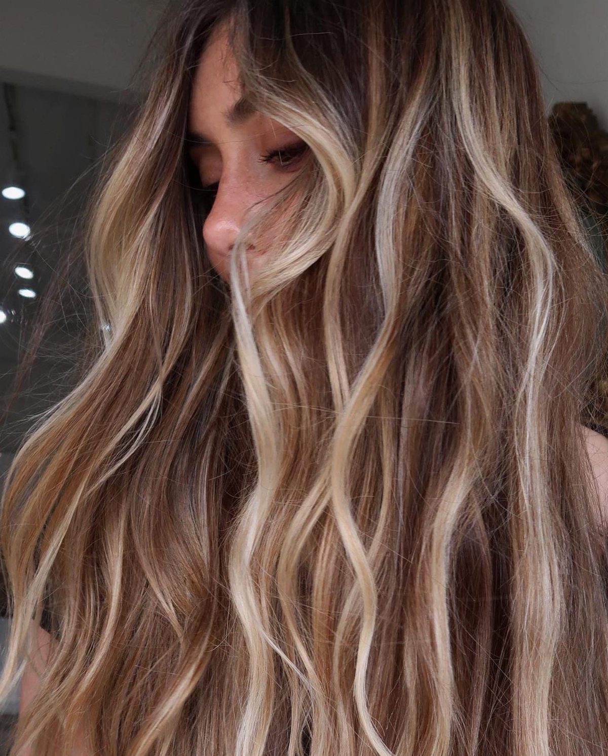 Wavy brown hair with high-contrast blonde balayage and bright face-framing strands