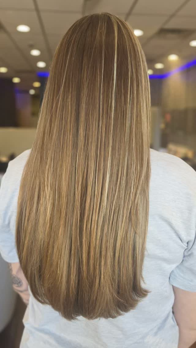 Long light brown hair with fine blonde highlights falls down the back