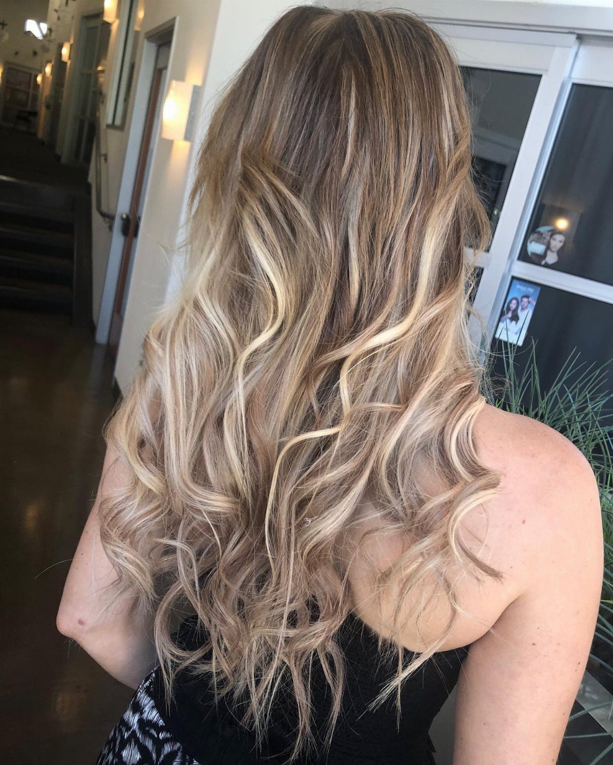 Long brown hair with warm sandy blonde accents and loose waves