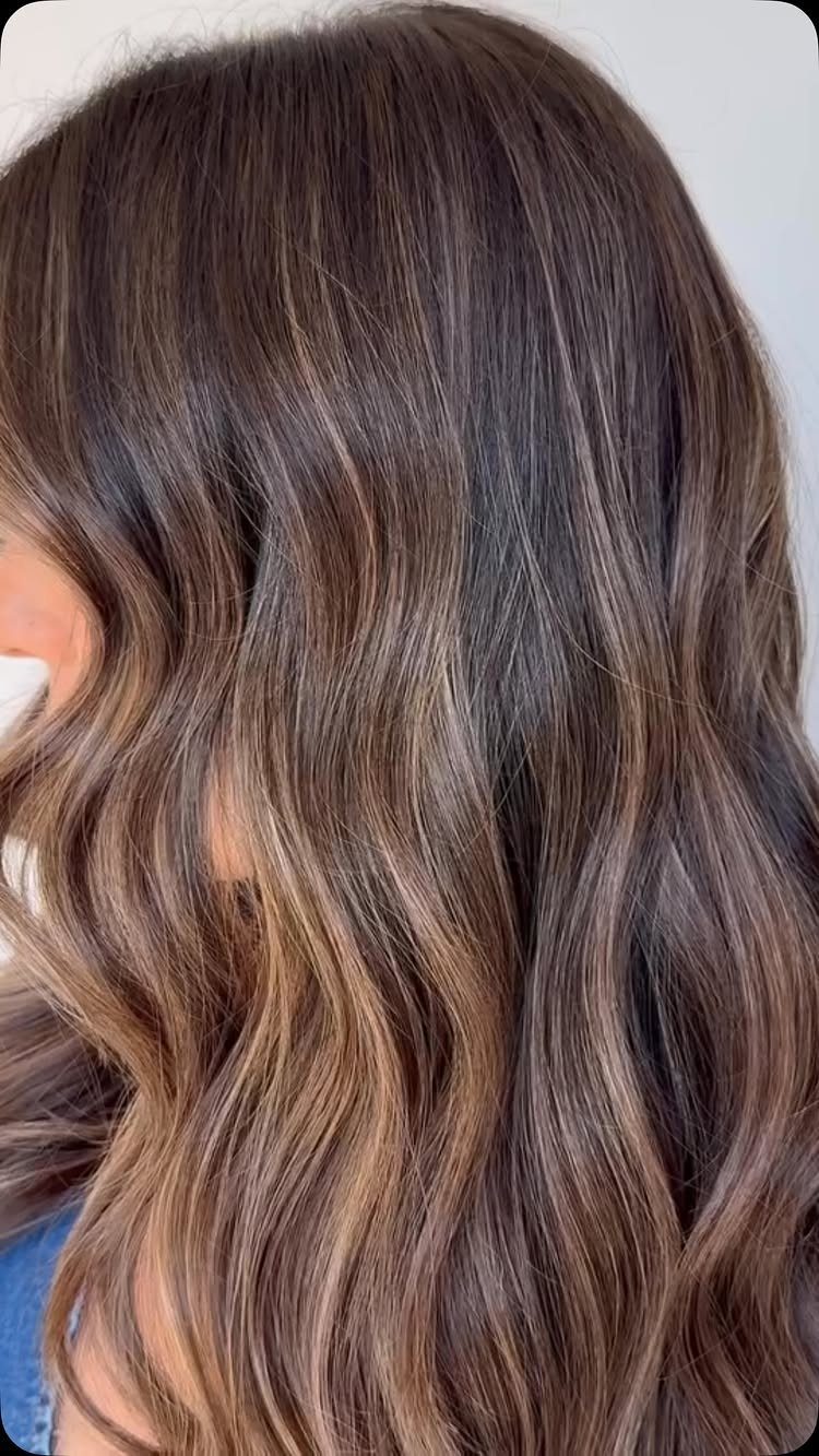 Wavy dark brown hair featuring fine blended caramel babylights