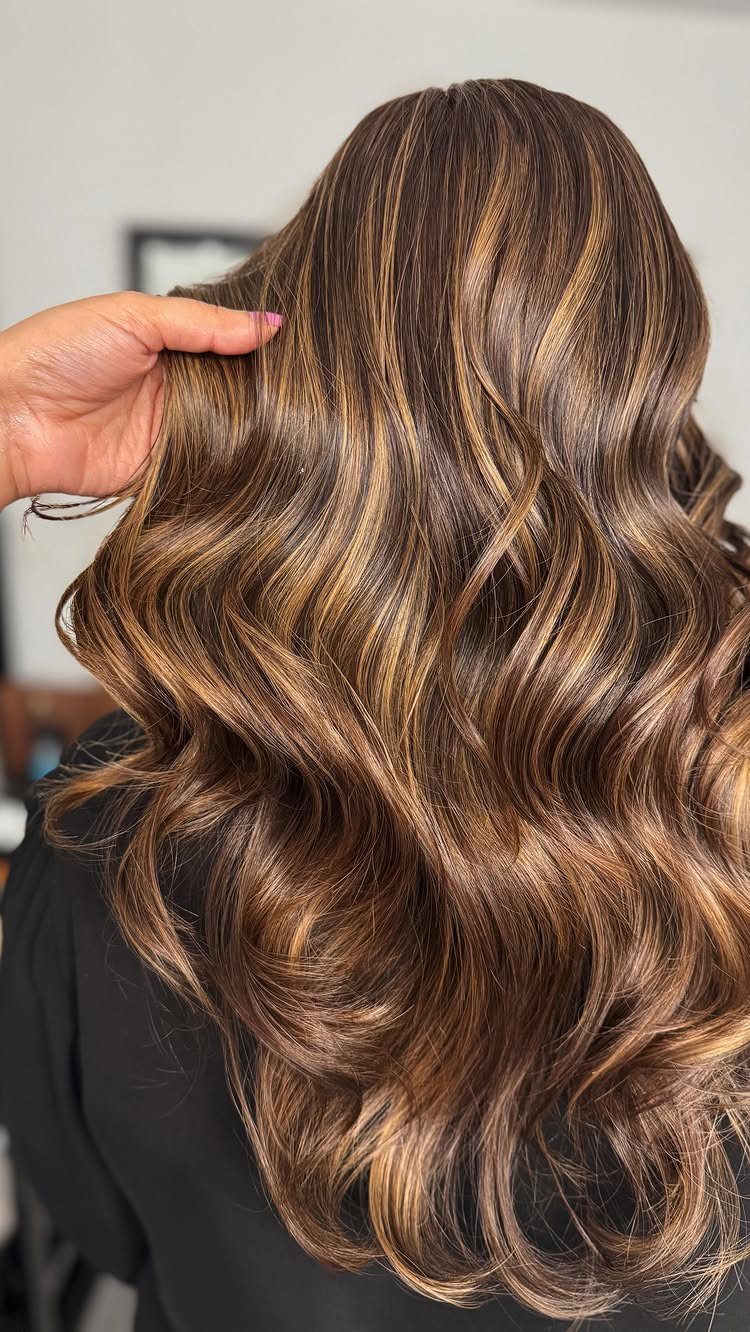 Long brunette curls show blended caramel ribbons and dimensional highlights