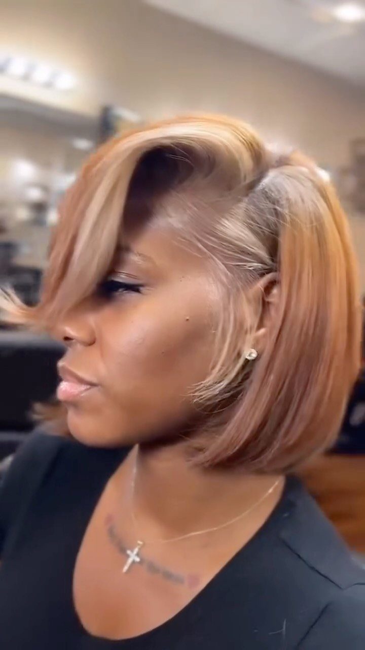 Woman showing a coppery caramel blonde bob with darker roots in a salon