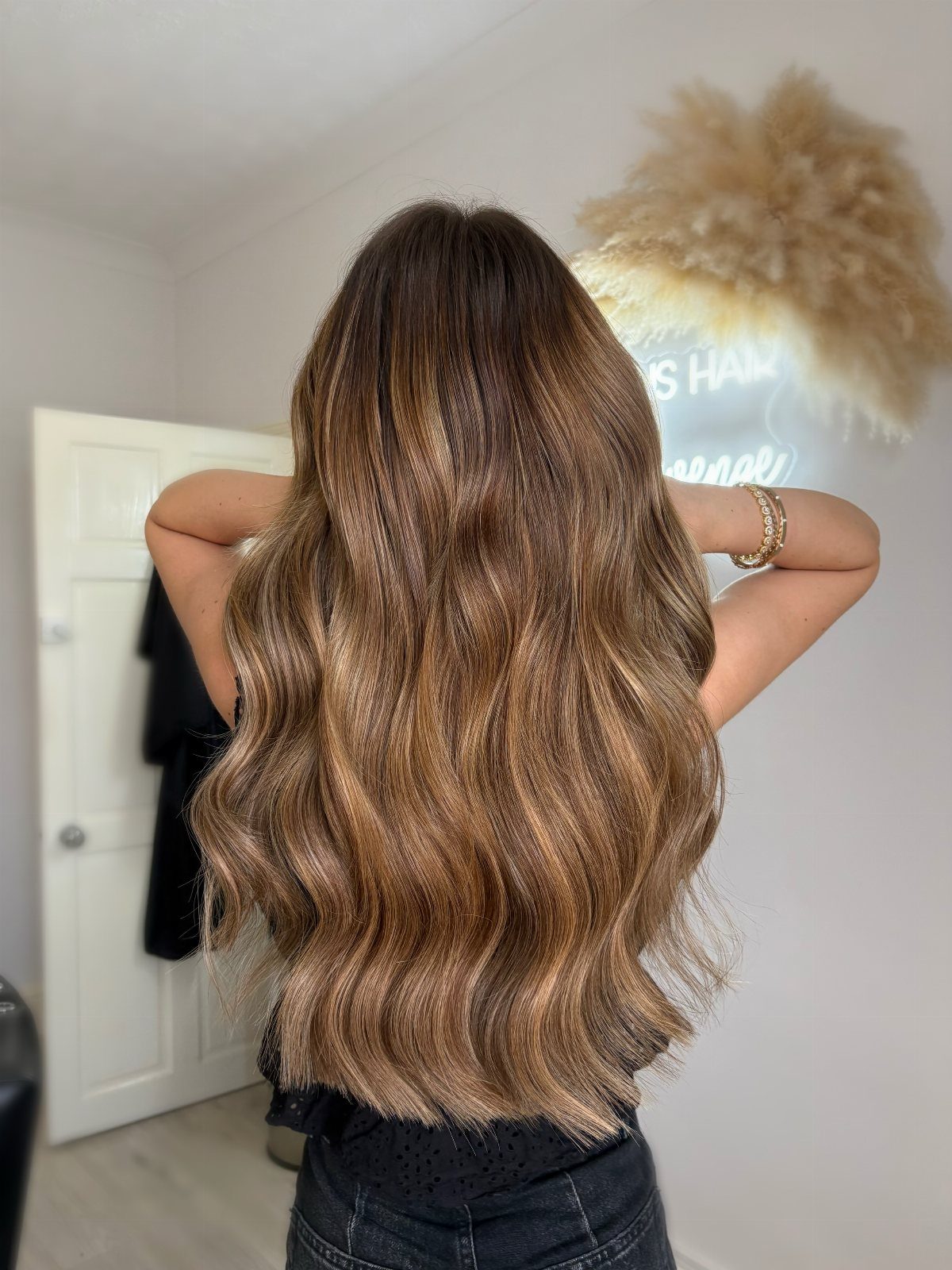 Long wavy brown hair blends coppery caramel tones with lighter highlighted strands