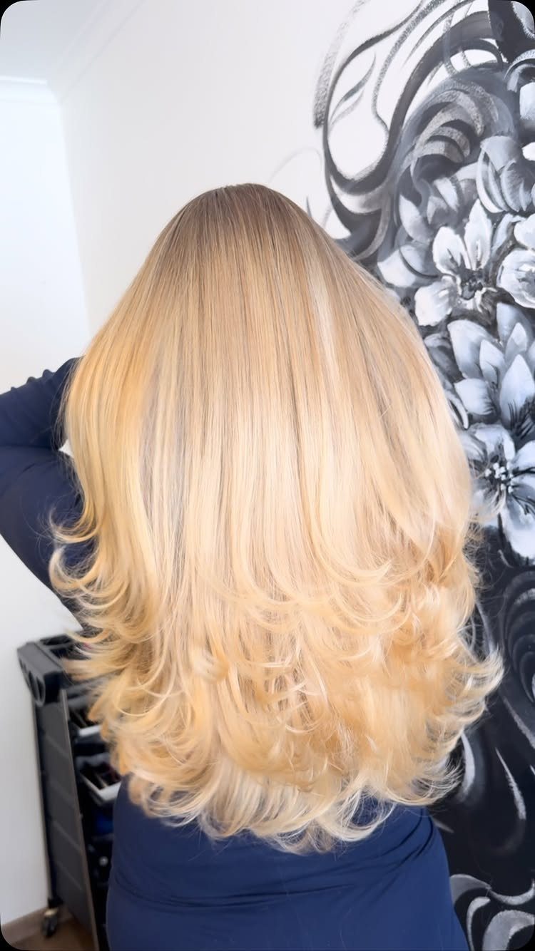 Long buttery dark blonde hair with warm golden layers and curled ends