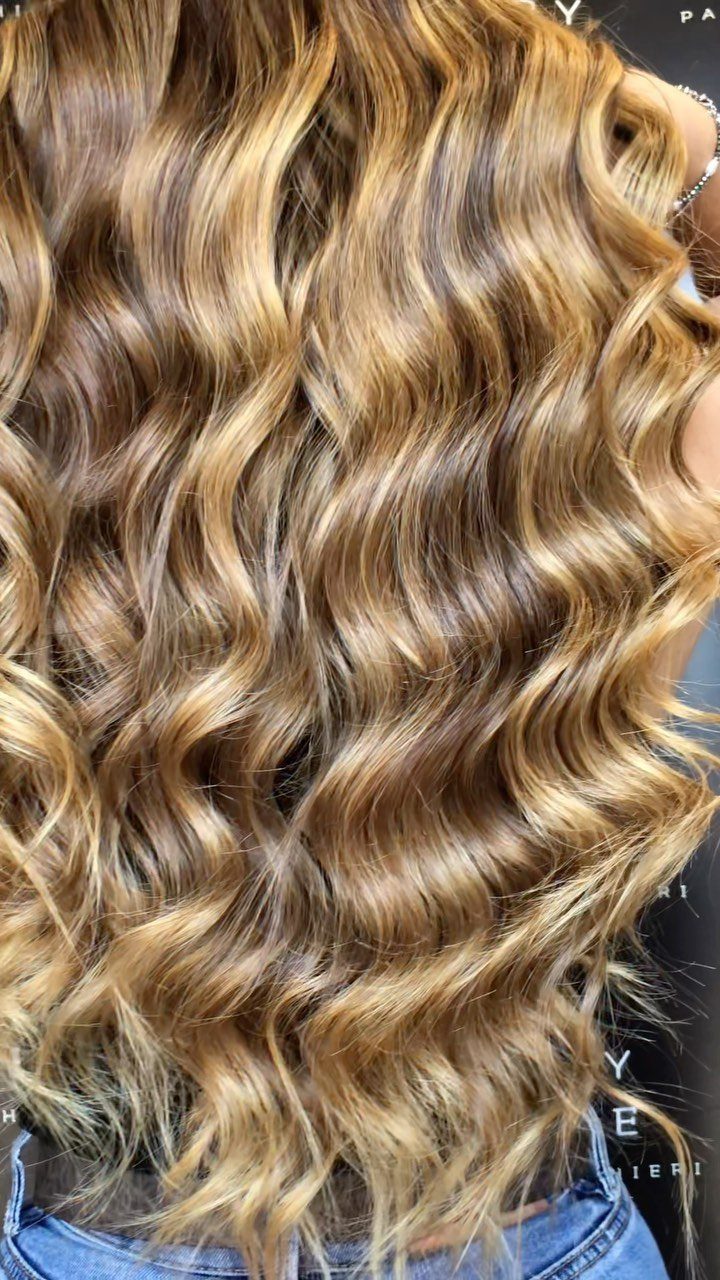 Wavy caramel blonde hair with golden-brown and light blonde highlights