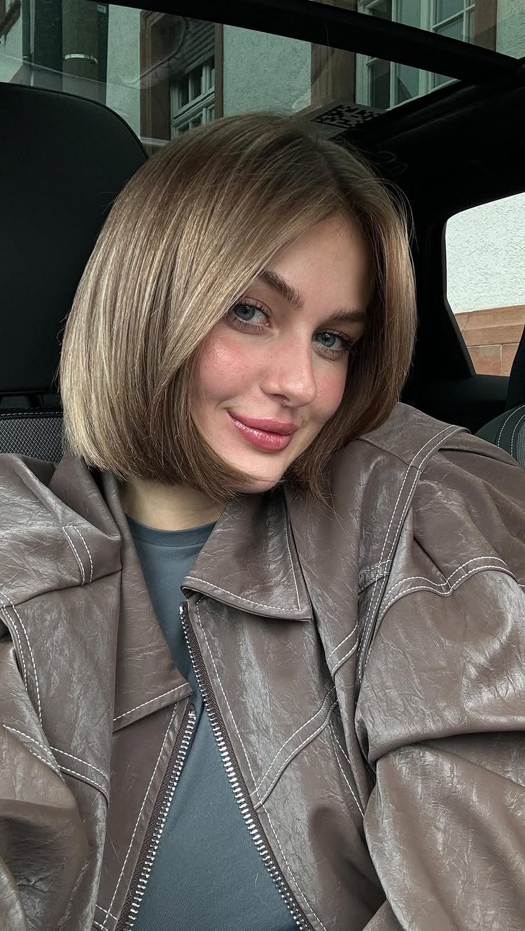 Woman showing a glossy chocolate blonde bob while seated inside a car
