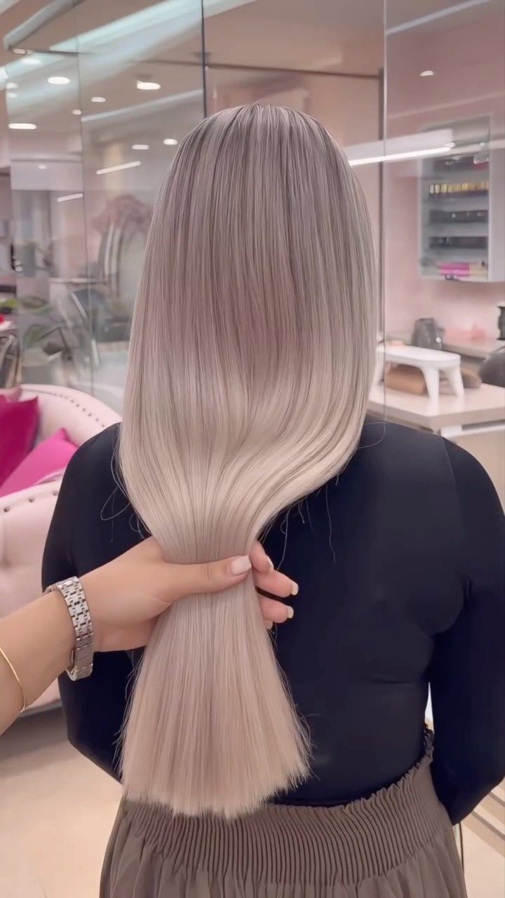 Long silver-blonde ponytail gathered in a bright salon