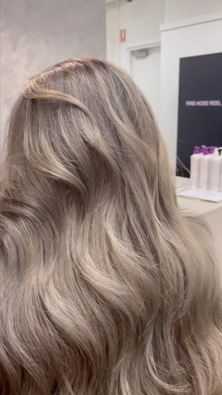 Dark ash blonde hair with cool smoky tones and loose waves