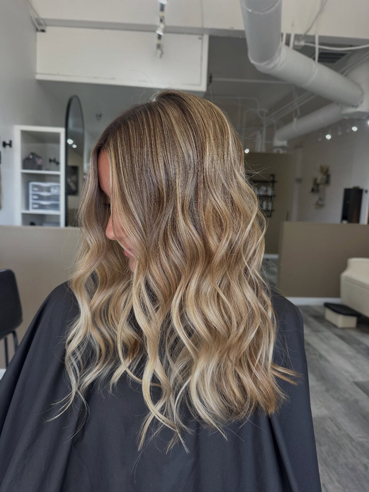 Wavy blonde hair with darker roots and blended cool and golden highlights