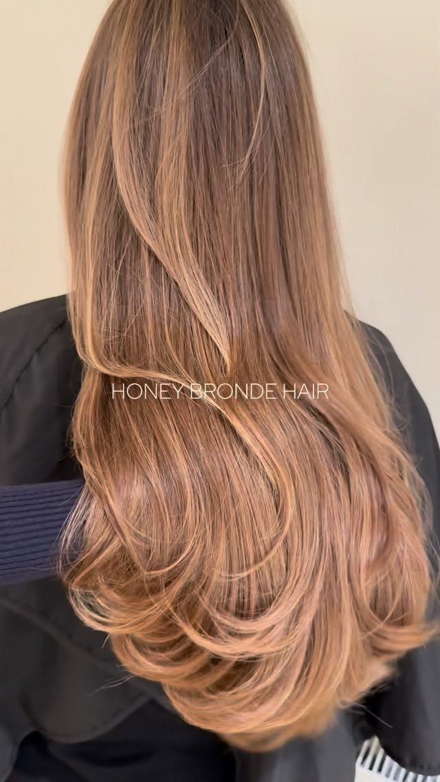 Long honey blonde hair with warm highlights and softly curled layered ends