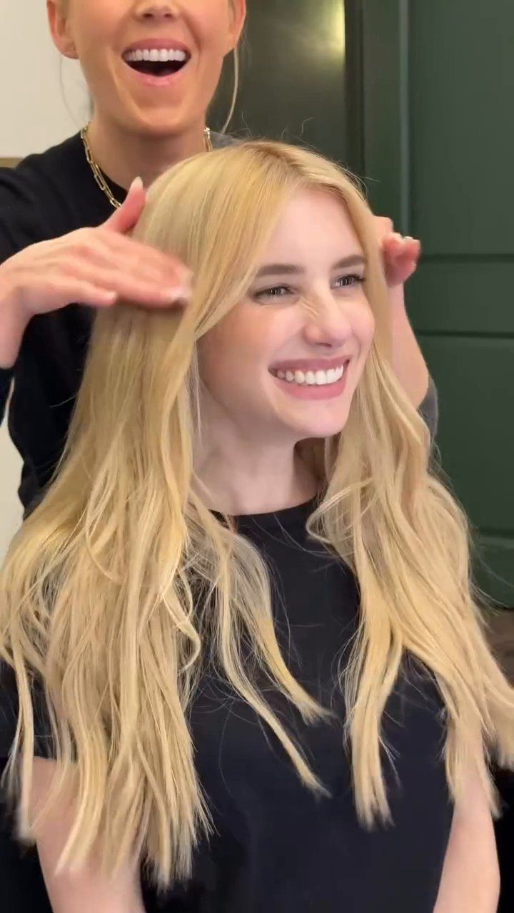 Woman with long, light blonde hair smiling in a salon chair