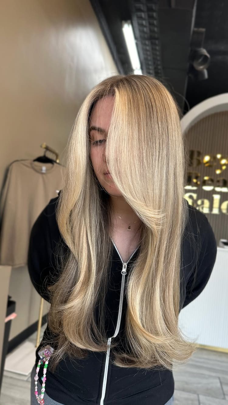 Long blonde hair with bright face-framing pieces and darker blonde lengths