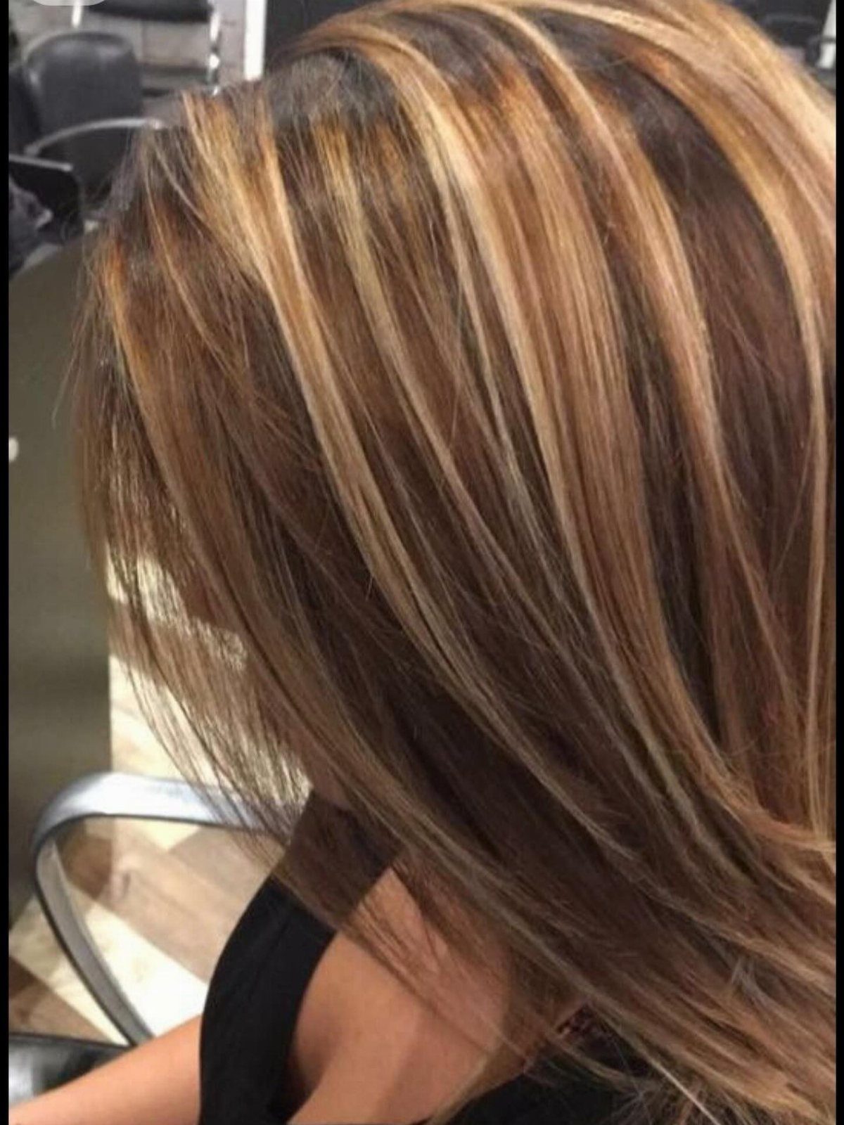 Brown hair with chunky warm blonde ribbons falling in smooth, straight sections