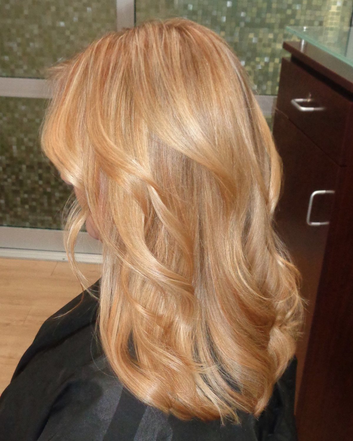 Golden strawberry-blonde hair with honey warmth and soft curls